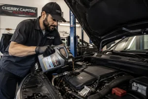 Mechanic performing engine oil change service at Cherry Capital Auto Clinic in Traverse City